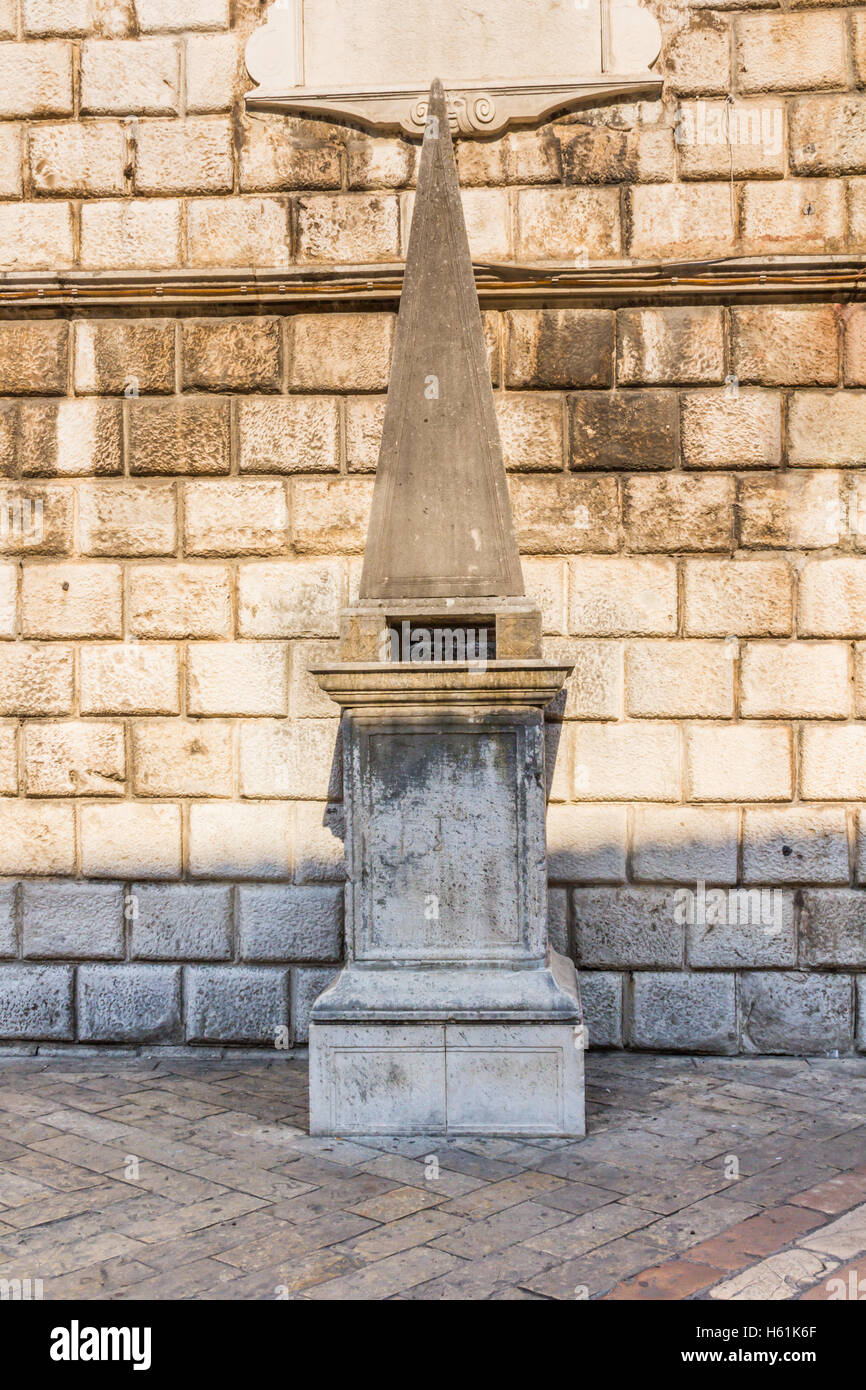 RECONSTRUCTED PILLORY, KOTOR, MONTENEGRO - CIRCA AUGUST, 2016. A reconstructed medieval pillory stands in front of the Clock Tow Stock Photo