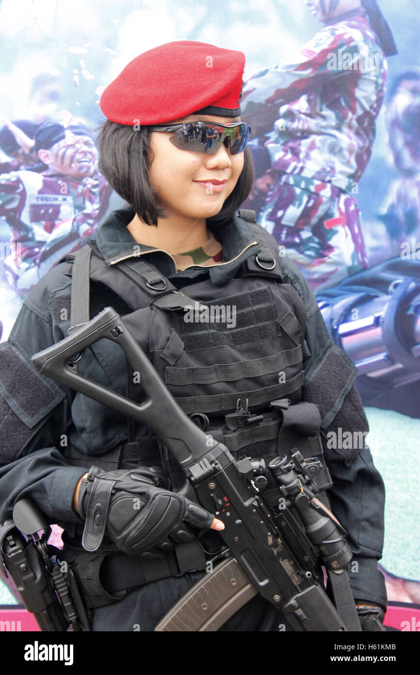 Army woman of Kopassus elite force handling a sub machine gun in Indonesian Armed Force Exhibition. Stock Photo