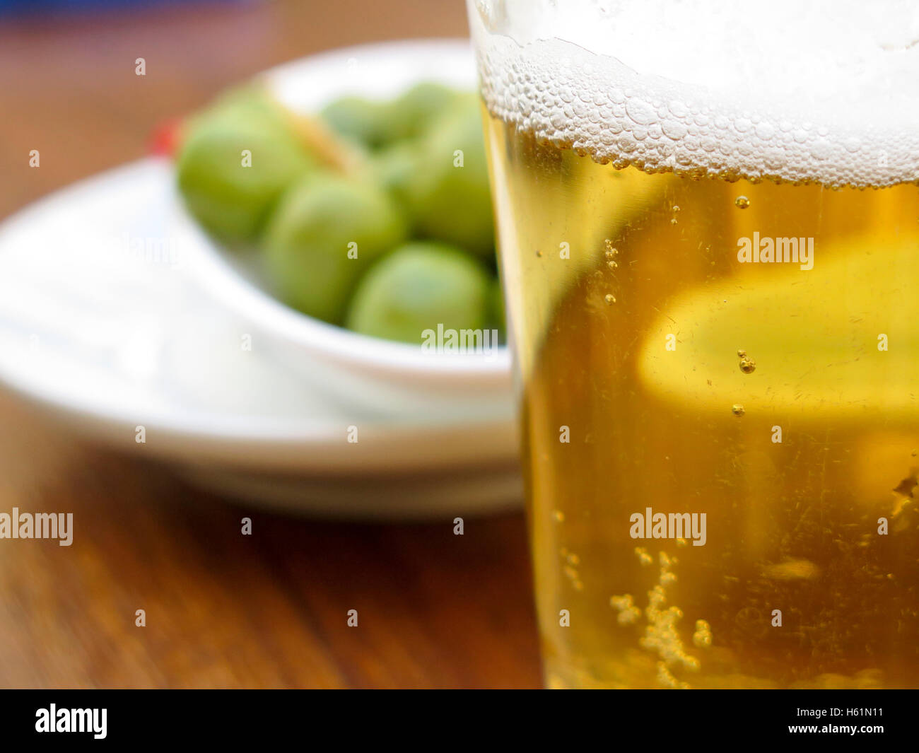 Pint of beer served with olives Stock Photo Alamy