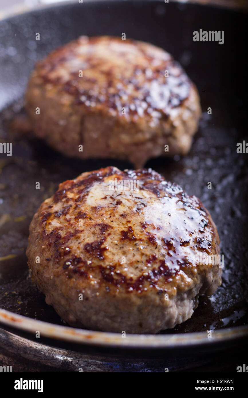 Two beef hamburgers are being pan fried Stock Photo Alamy