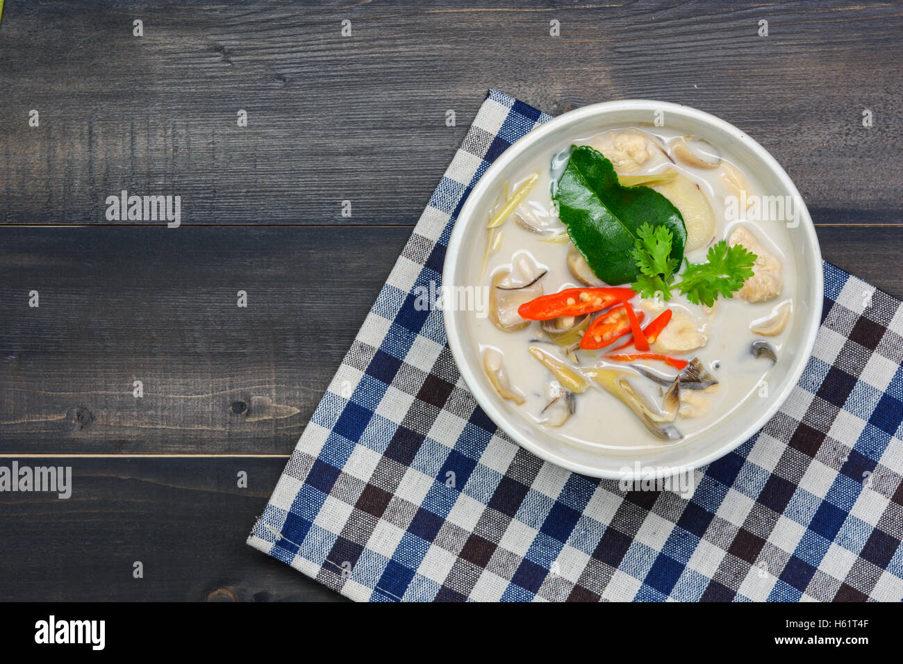 coconut milk soup with chicken or Thai chicken coconut Soup ( Tom Kha Gai ) on wooden table top view, Thai local food Stock Photo