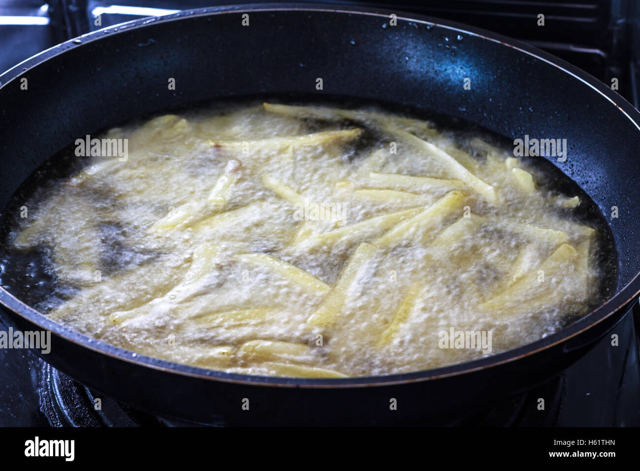 Chips, potatoes frying in the pan in olive oil Stock Photo Alamy