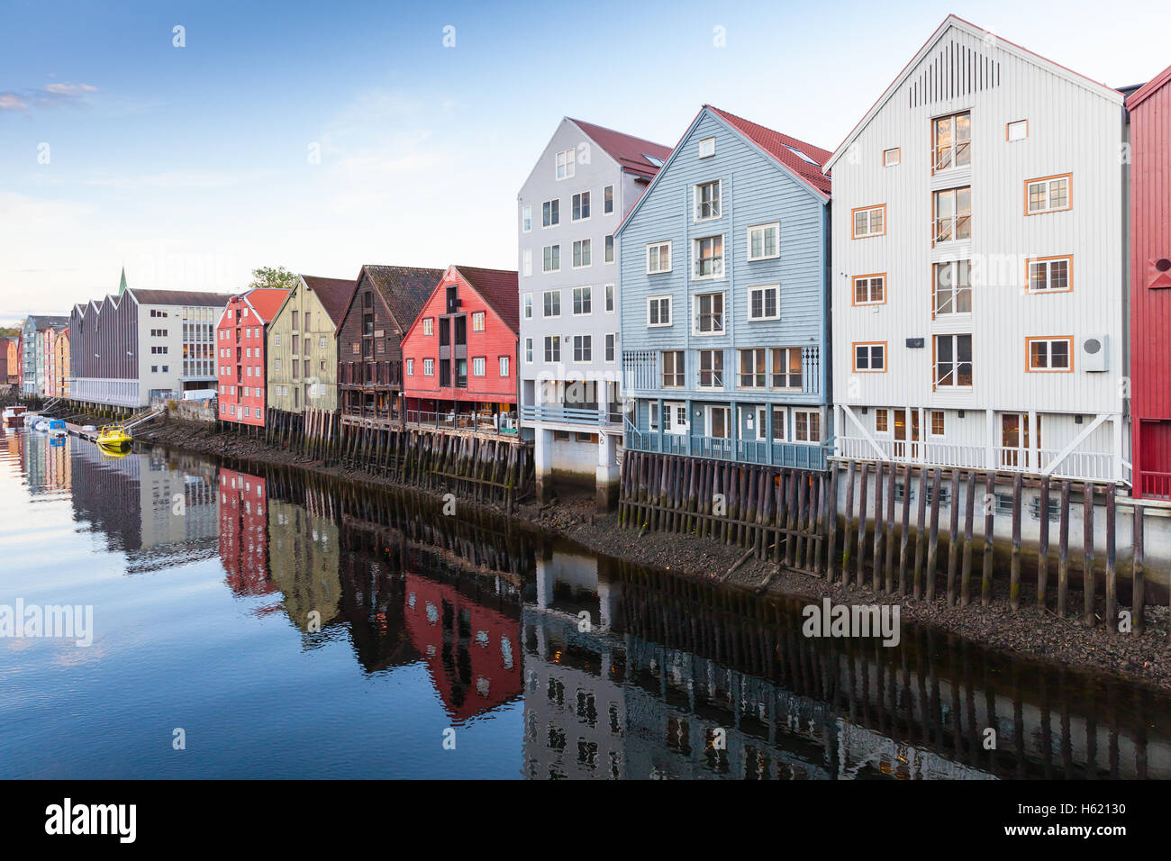 Colorful old wooden houses stand along Nidelva river coast. Trondheim, Norway Stock Photo