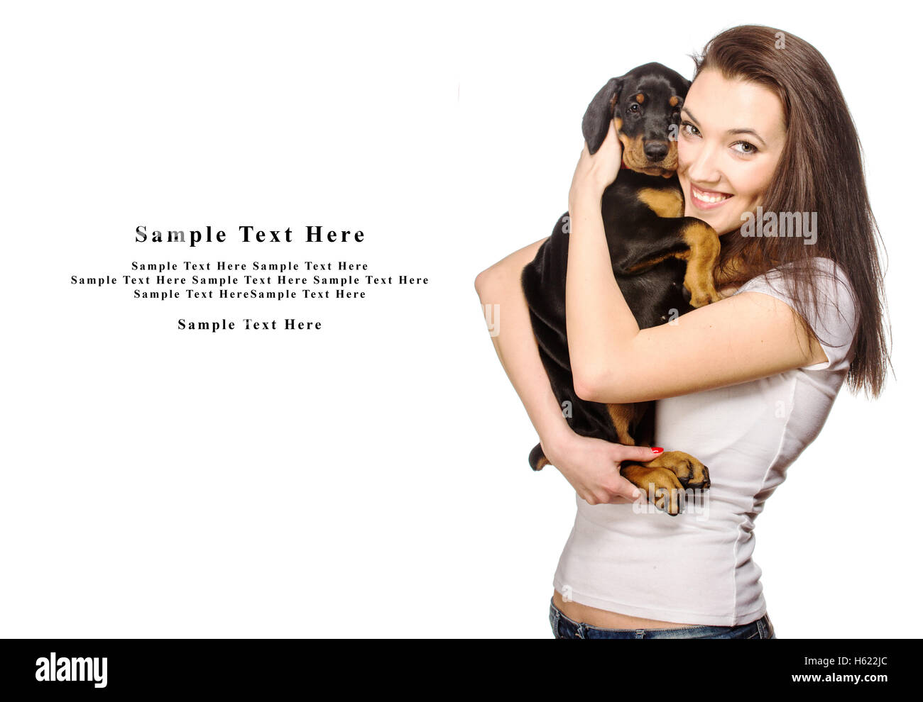 Brunette girl with her doberman puppy isolated on white background Stock Photo