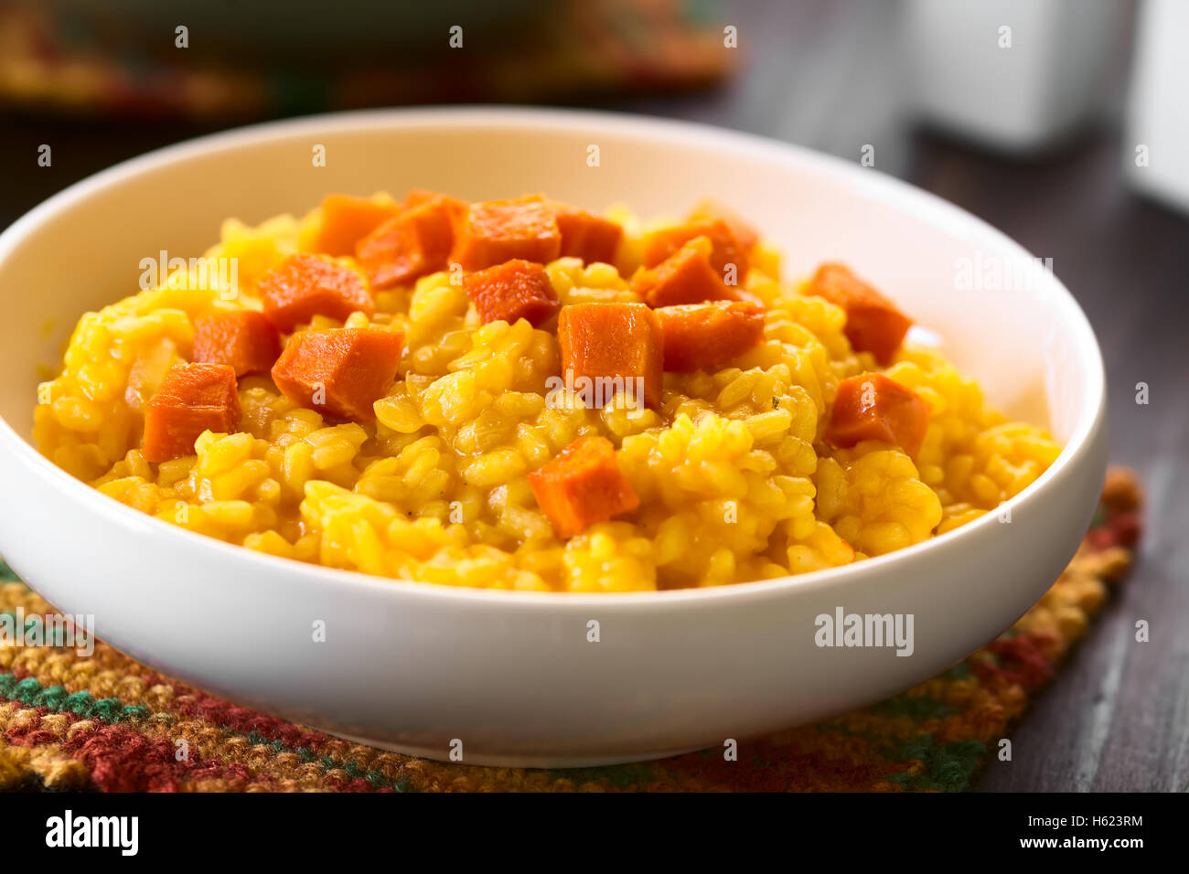 Pumpkin risotto prepared with pumpkin puree, roasted pumpkin pieces on top, photographed with natural light (Selective Focus) Stock Photo