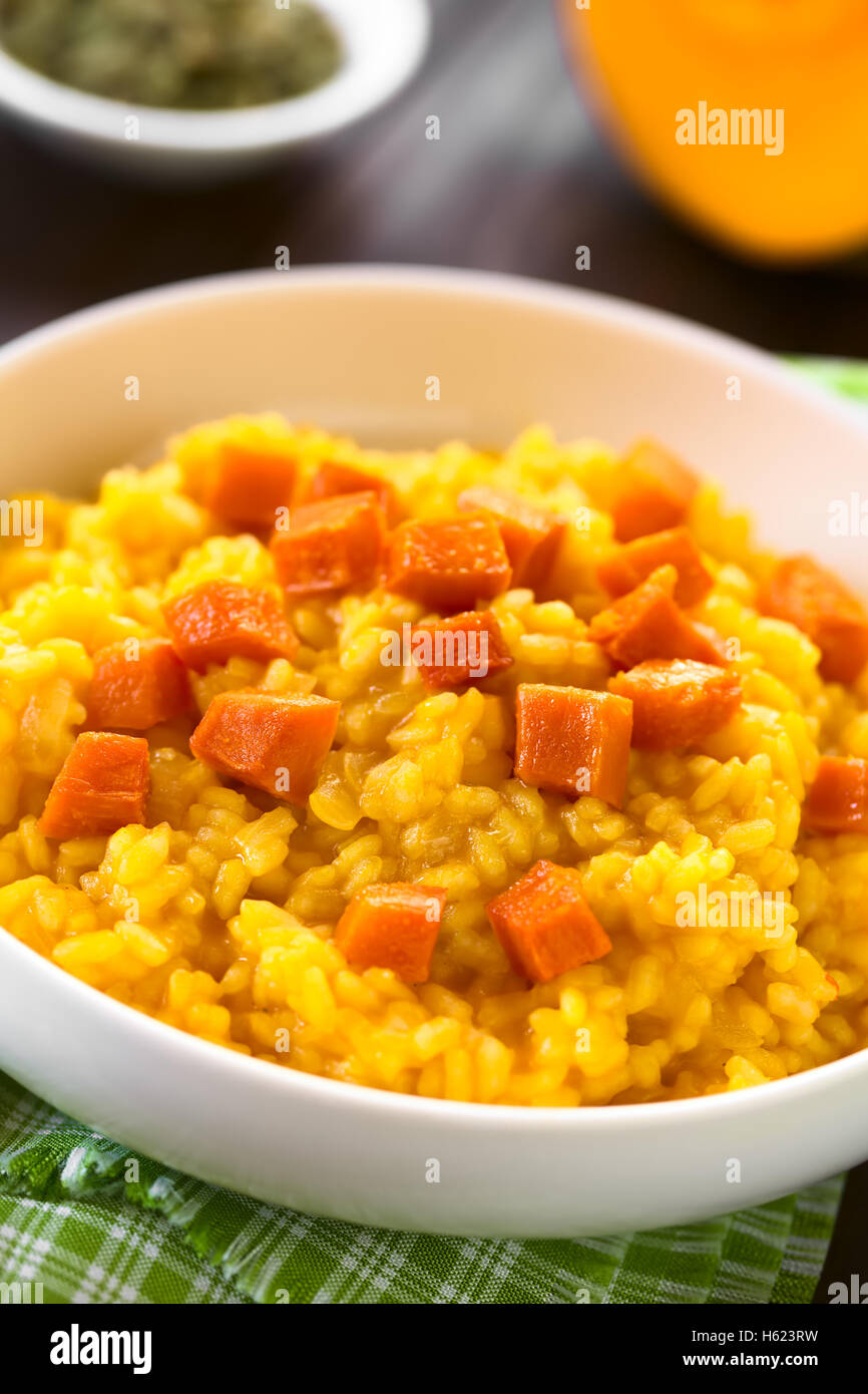 Pumpkin risotto prepared with pumpkin puree, roasted pumpkin pieces on top, photographed with natural light (Selective Focus) Stock Photo