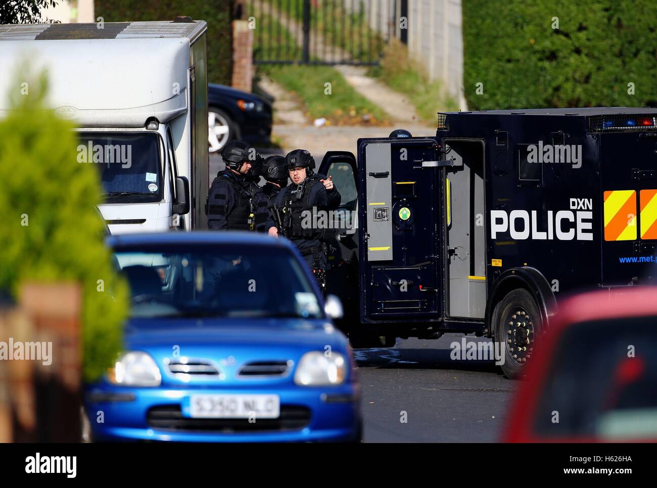 Armed police officers at the scene in Northolt, London, where they remain locked in a stand-off with a man at an address in Wood End Lane, who is said to be in possession of dangerous items including petrol and combustibles. Stock Photo