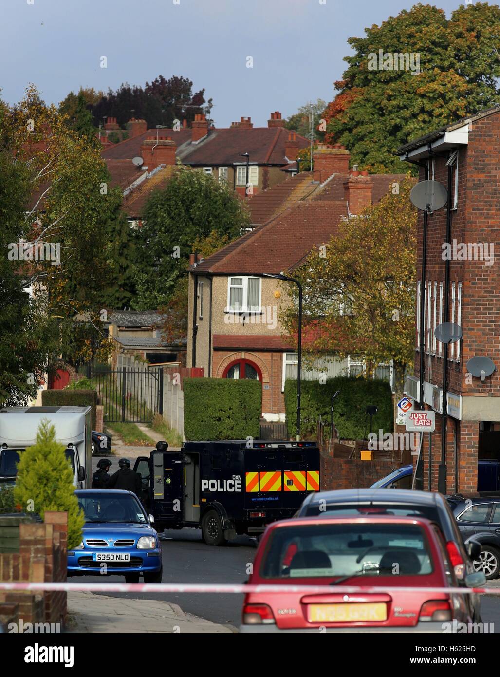 Armed police officers at the scene in Northolt, London, where they remain locked in a stand-off with a man at an address in Wood End Lane, who is said to be in possession of dangerous items including petrol and combustibles. Stock Photo