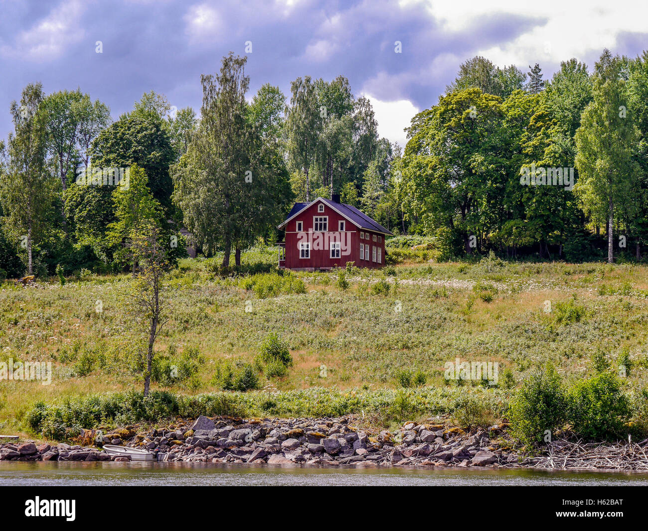 Typical red wood house on a lake in Sweden Stock Photo - Alamy