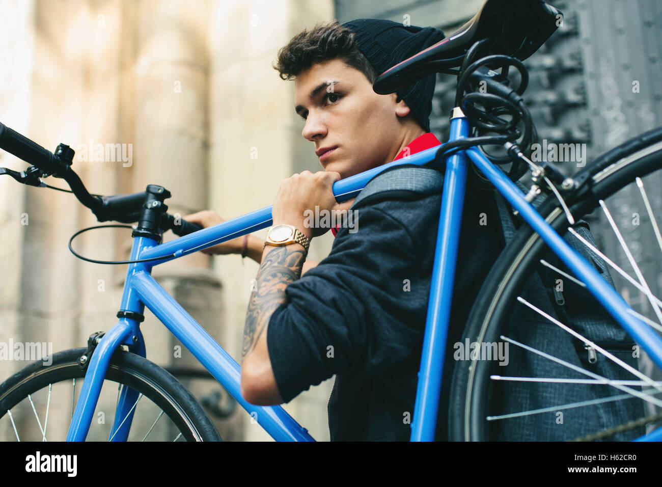 Teenager carrying fixie bike in the city Stock Photo