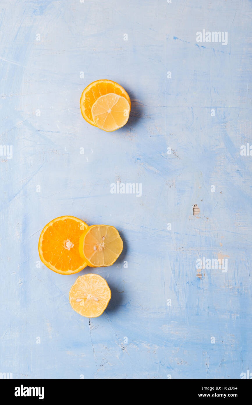 Lemon and orange slices on blue background Stock Photo - Alamy