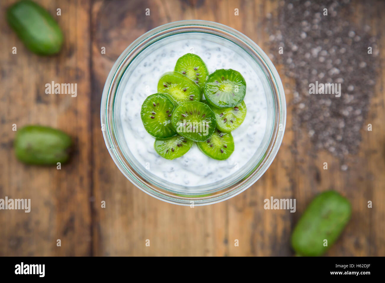 Glass of natural yoghurt with chia seeds and slices of hardy kiwis