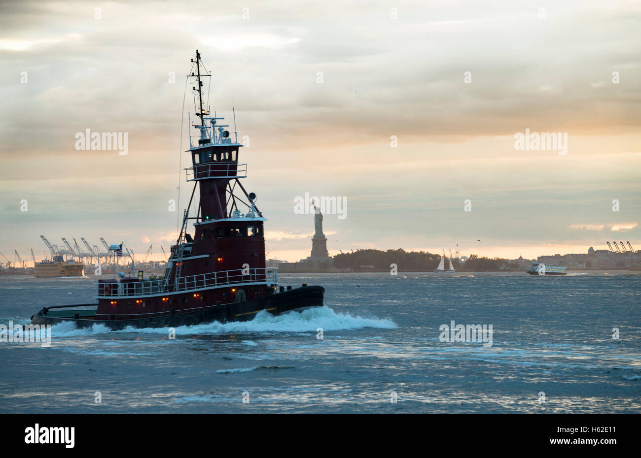 USA, New York City, tugboat on Upper New York Bay with Statue of Liberty in background Stock Photo