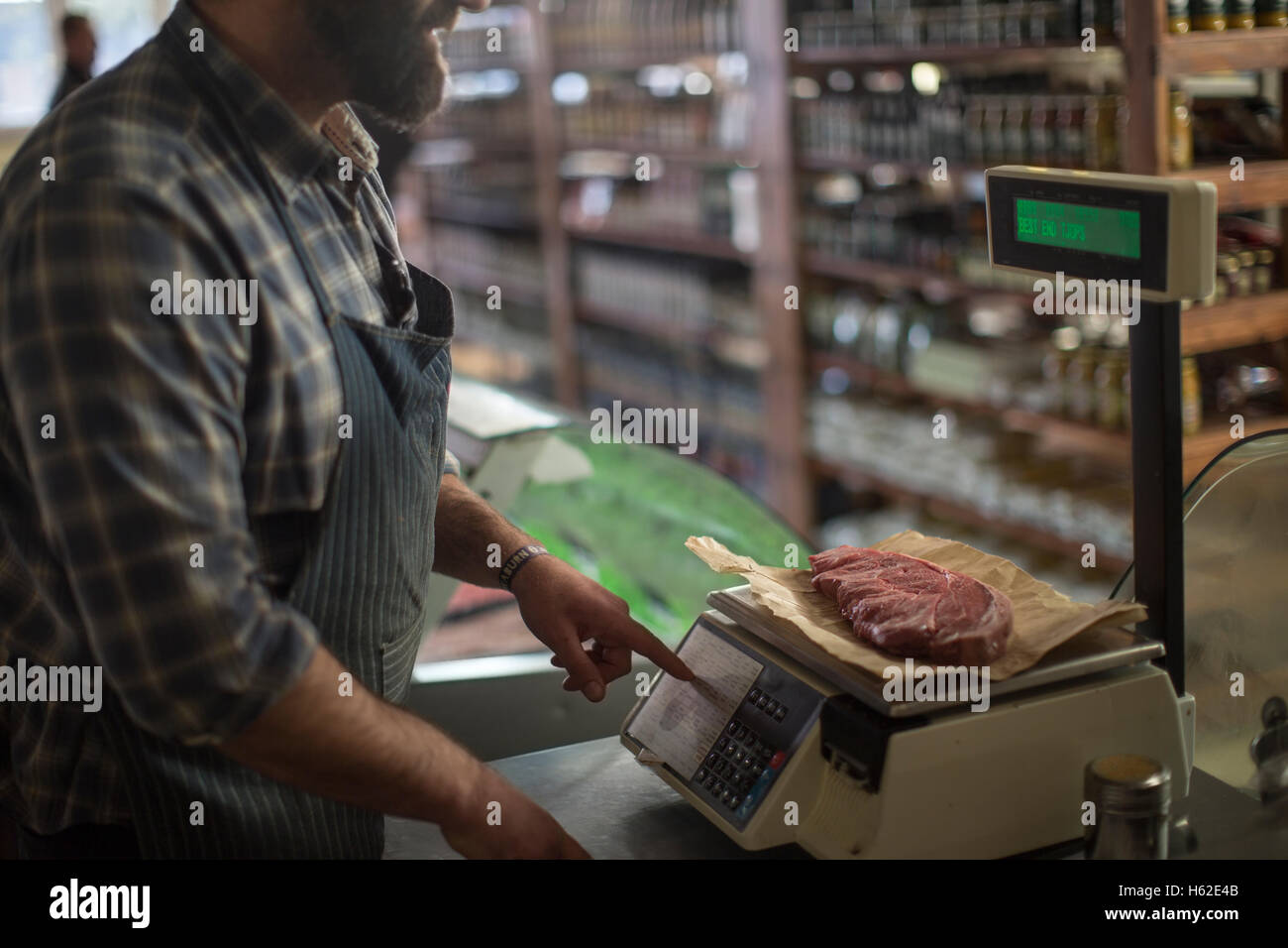 Butcher weighing meat on scale Stock Photo Alamy