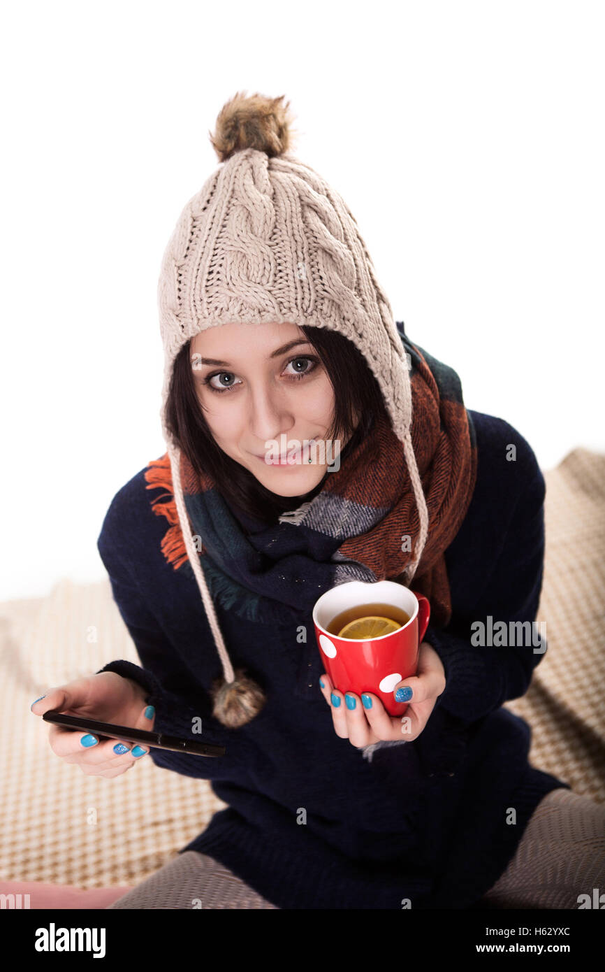 A beautiful young woman enjoying a hot drink under the blankets in bed