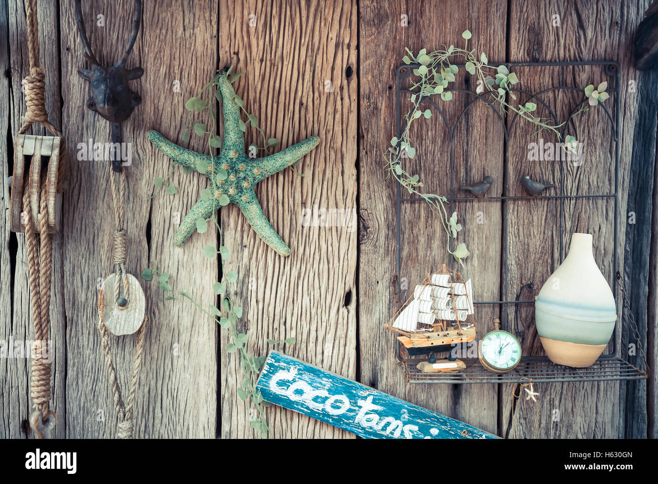 Vintage holidays still life with rope, starfish, compass and bottle on old wooden background Stock Photo
