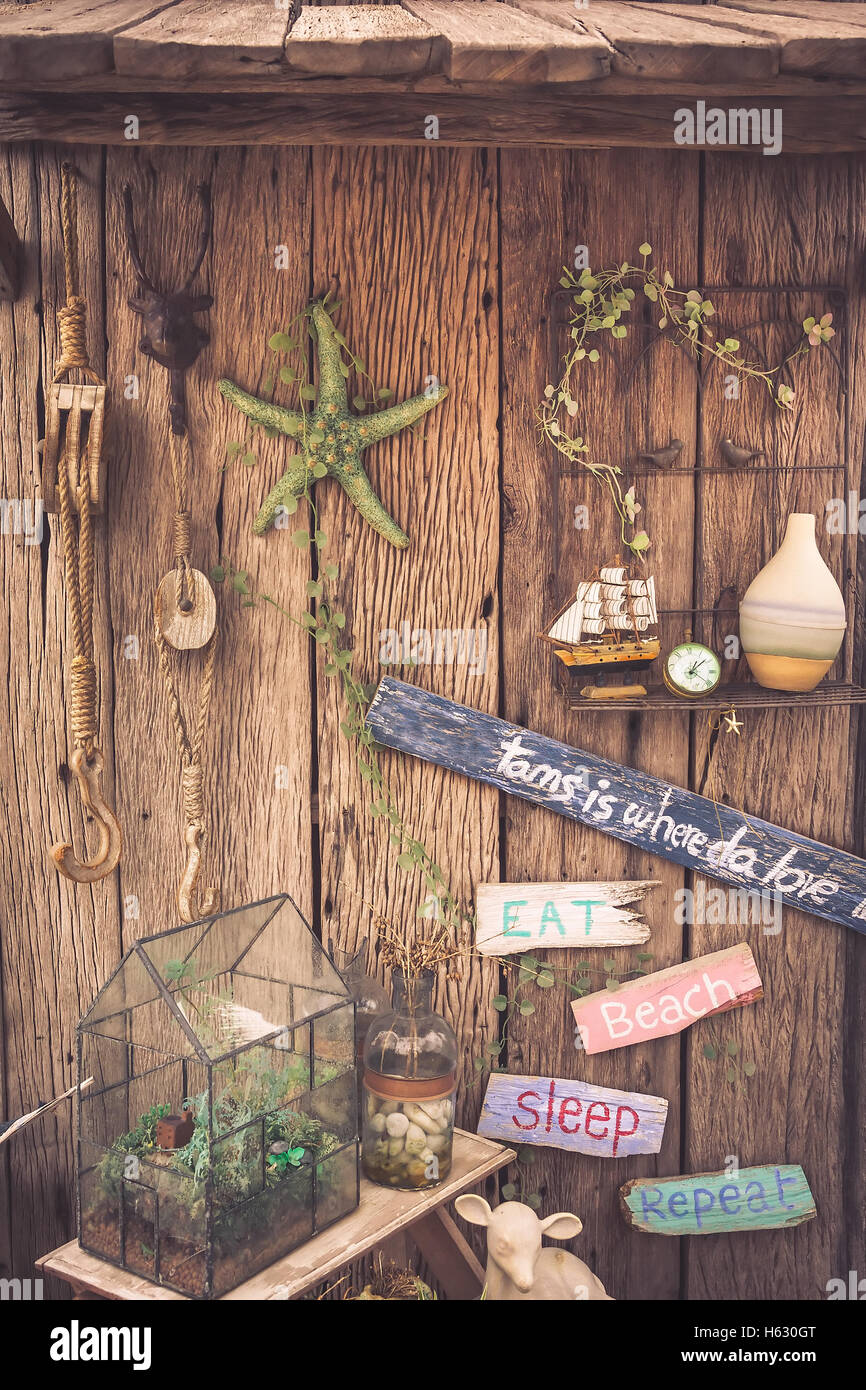 Vintage travel still life on old wooden fence with rope, starfish, compass, wooden signs and bottle Stock Photo