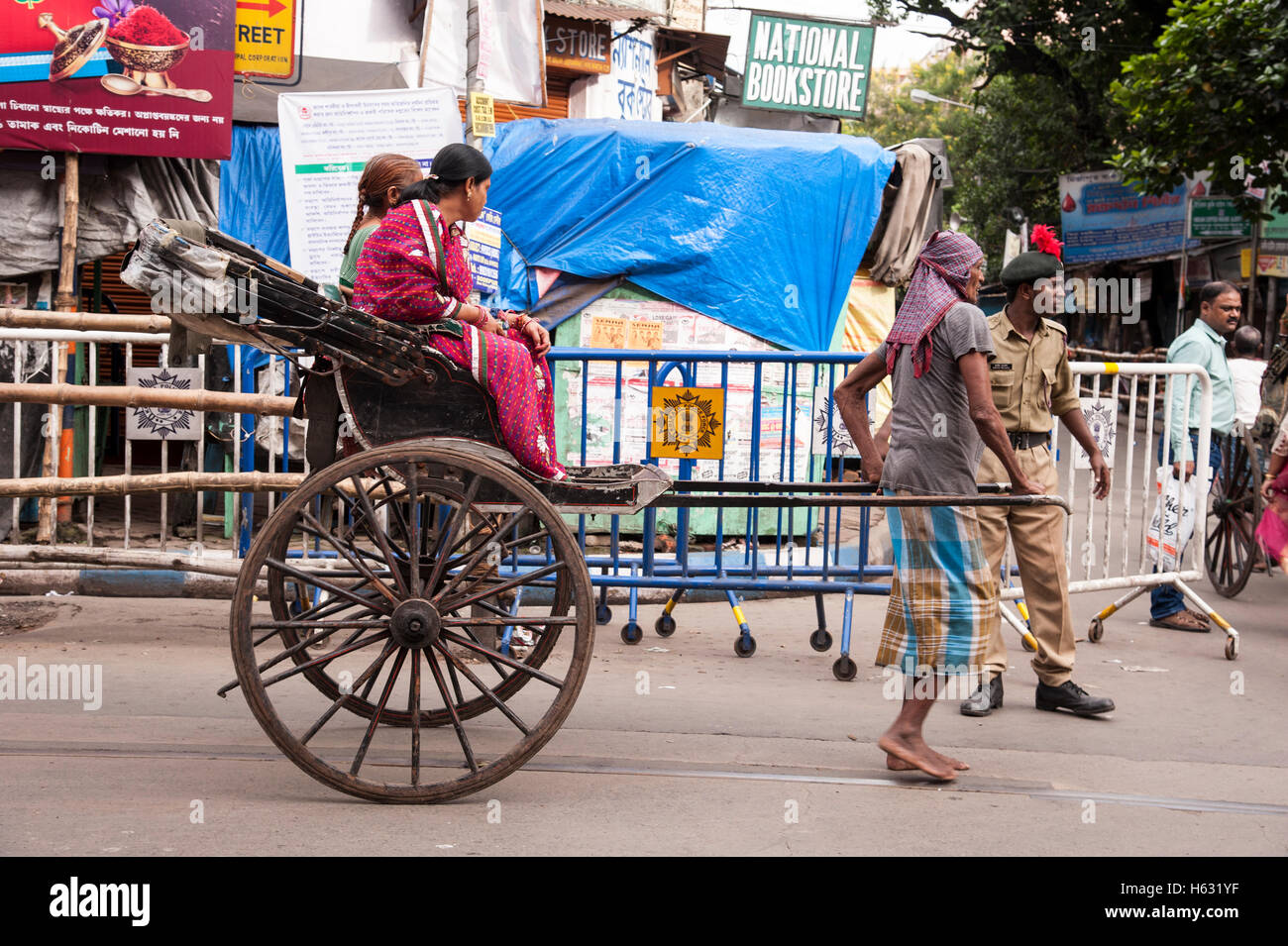 traditional hand pulled rickshaw puller pulling with passenger on street of Calcutta West Bengal India. Stock Photo