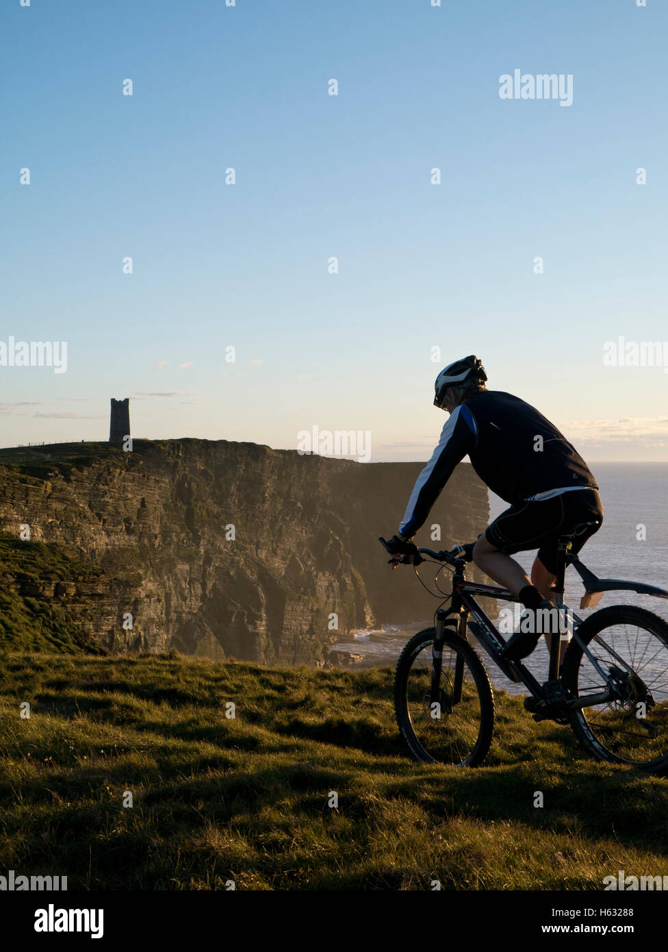 Cycling along the cliffs of Orkney Stock Photo