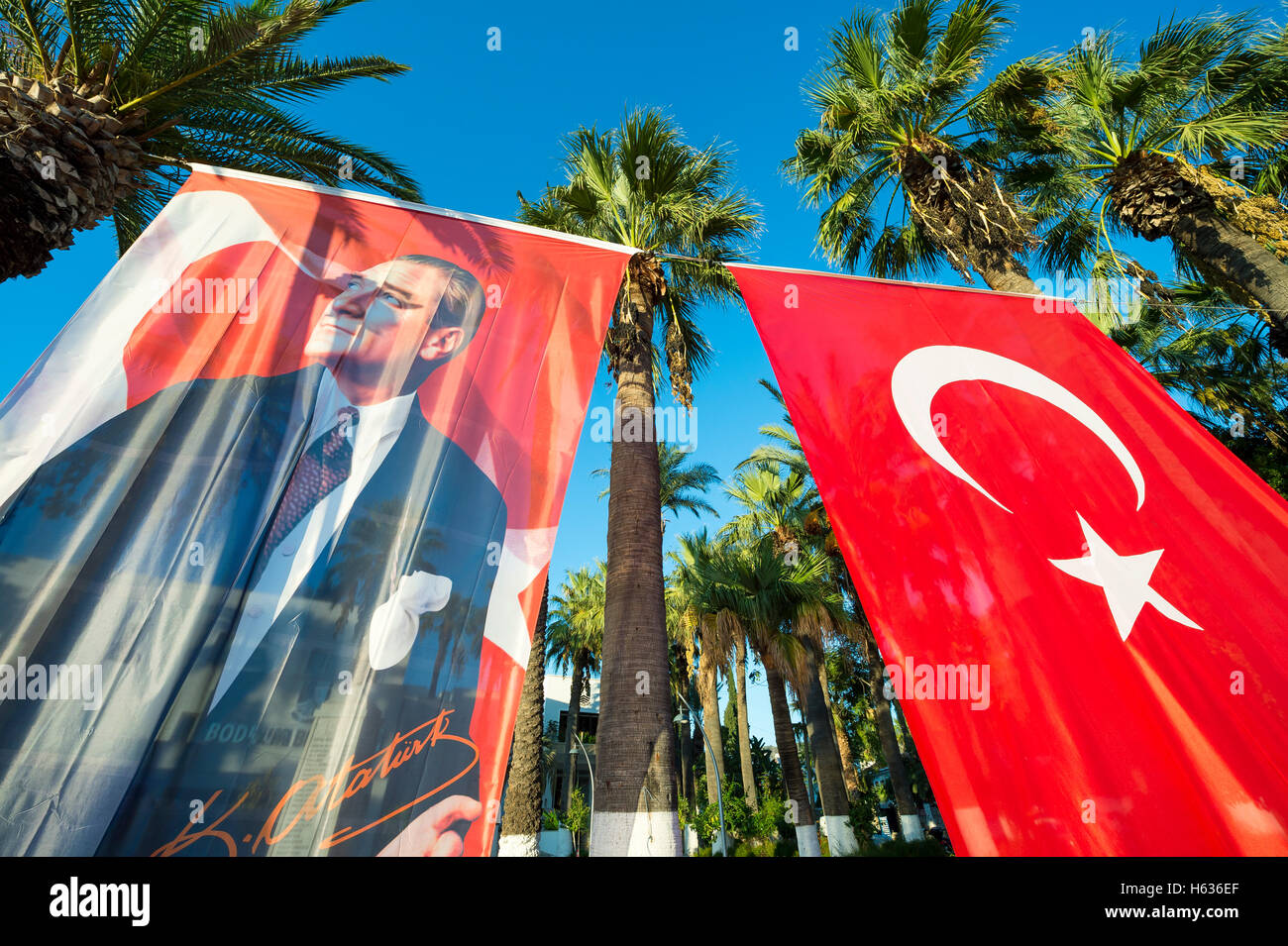 BODRUM, TURKEY - OCTOBER 6, 2016: Turkish flag hanging next to portrait of Mustafa Kemal Atatürk, the founder of the Republic. Stock Photo