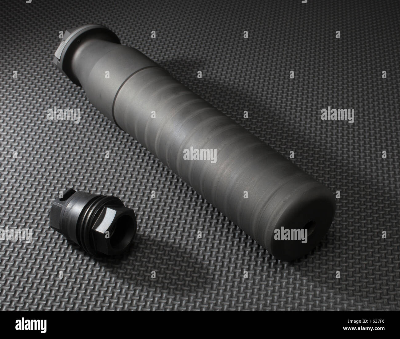 Suppressor with the adapter required to hold it on a rifle Stock Photo ...