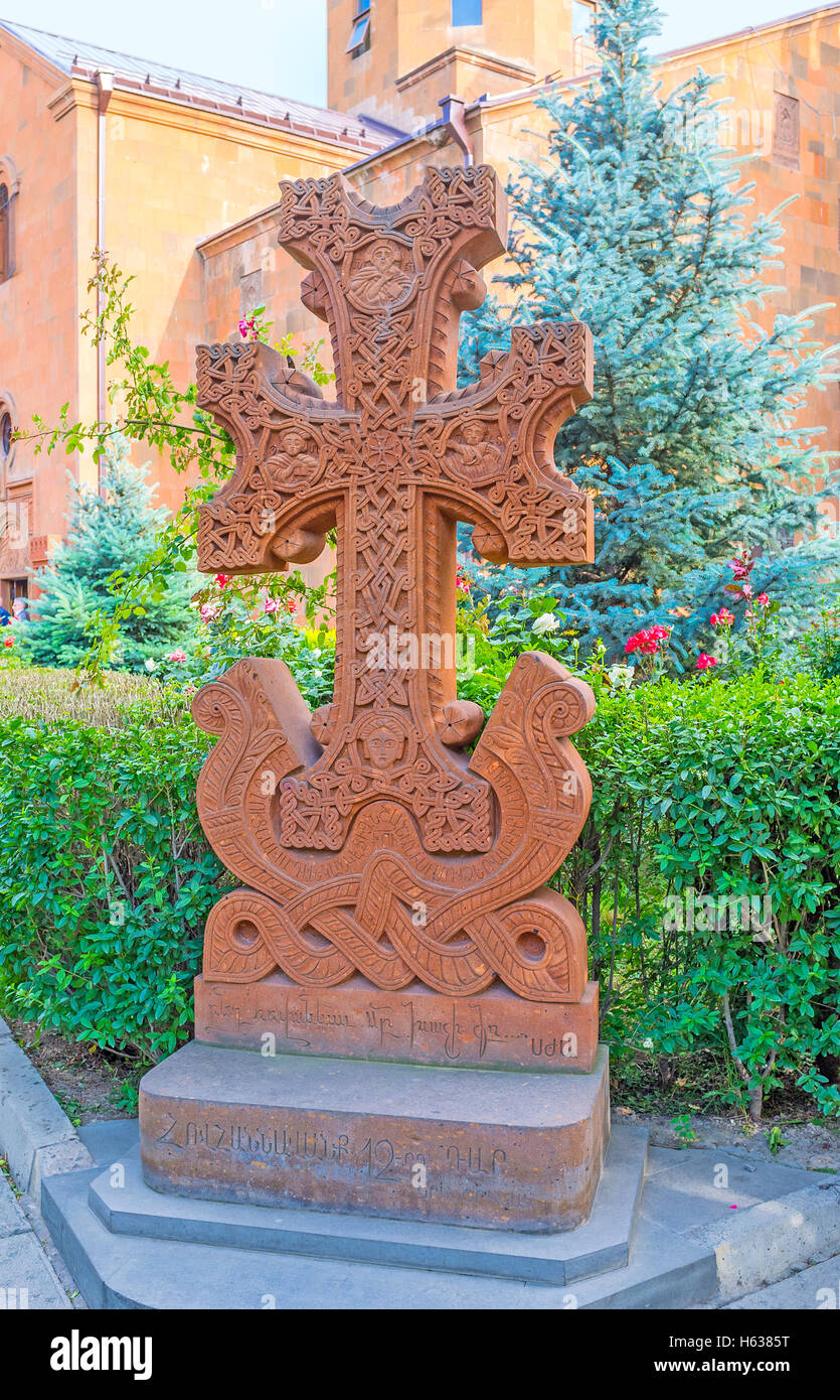 The red tuff Khachkar, carved with patterns and inscriptions, located in the courtyard of St John the Baptist Church Stock Photo