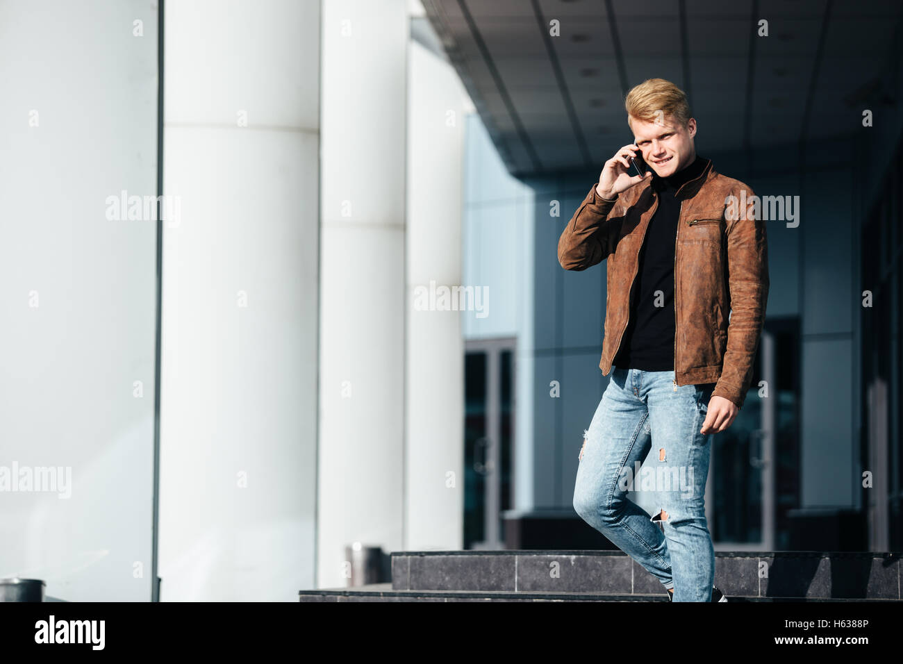 Young man talking on the phone, using smartphone, making a call. Stock Photo