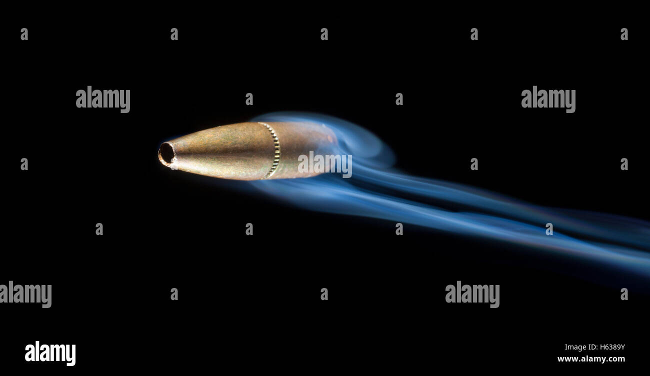 Copper colored bullet that appears to be speeding by the viewer Stock Photo