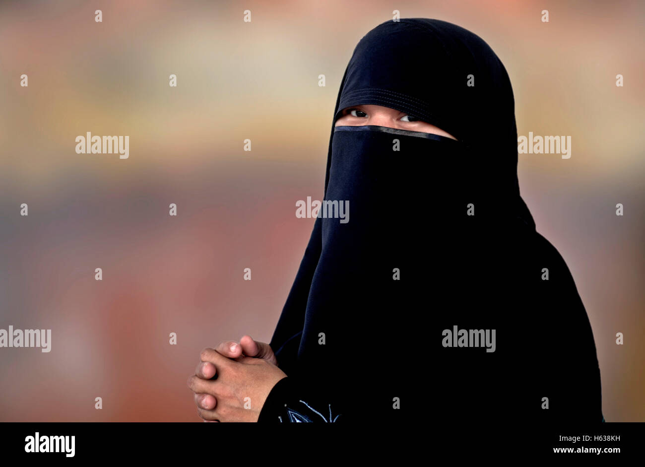 Muslim woman niqab burka isolated against a plain background. Woman eyes hijab Stock Photo