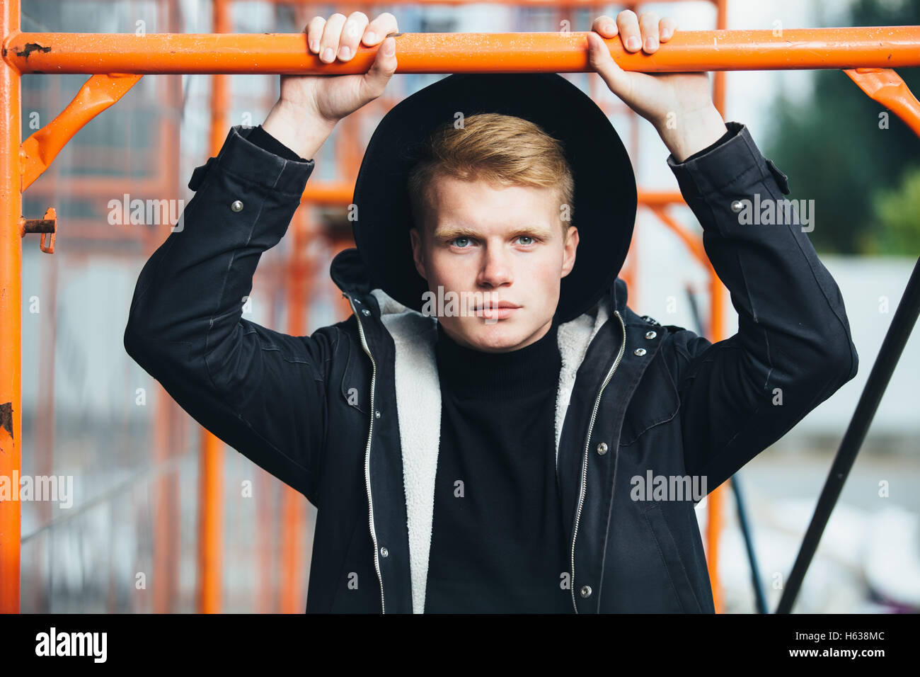 Young man posing with a trendy outfit against urban background Stock ...