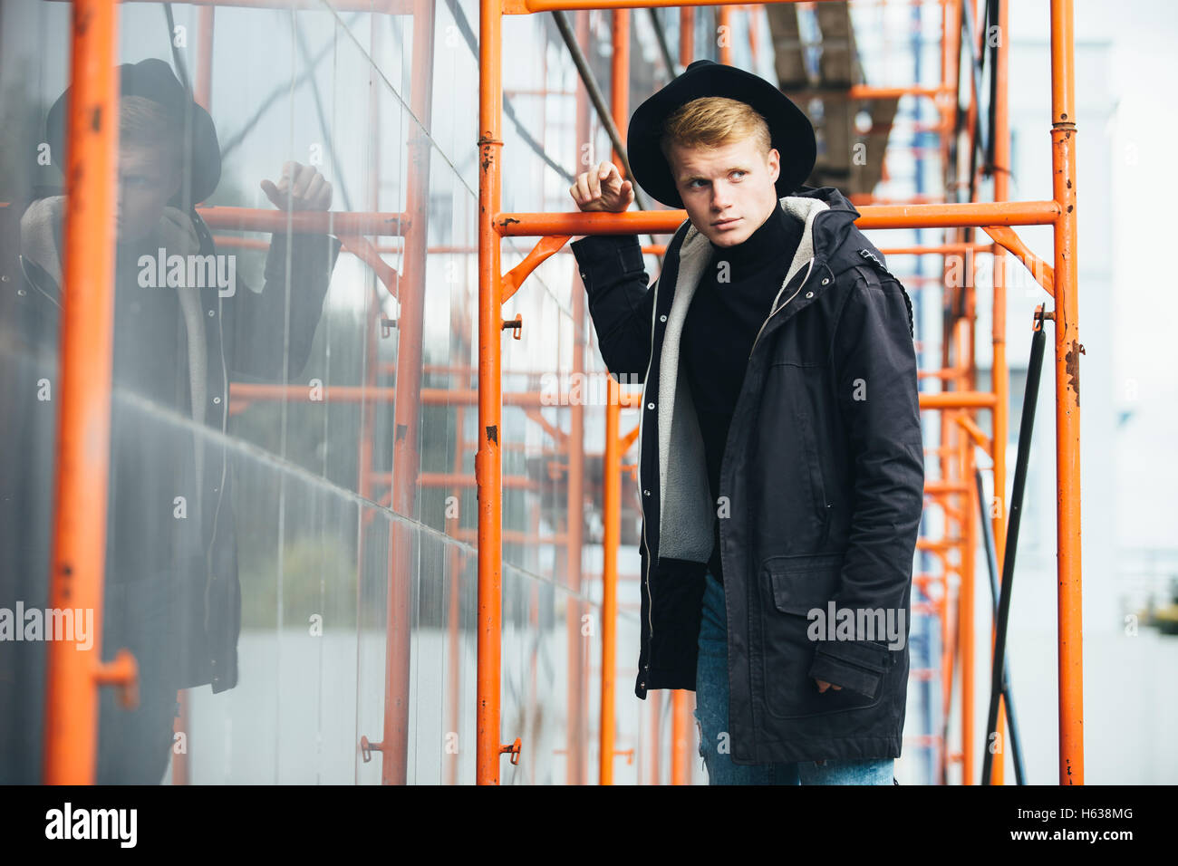 Young man posing with a trendy outfit against urban background Stock ...