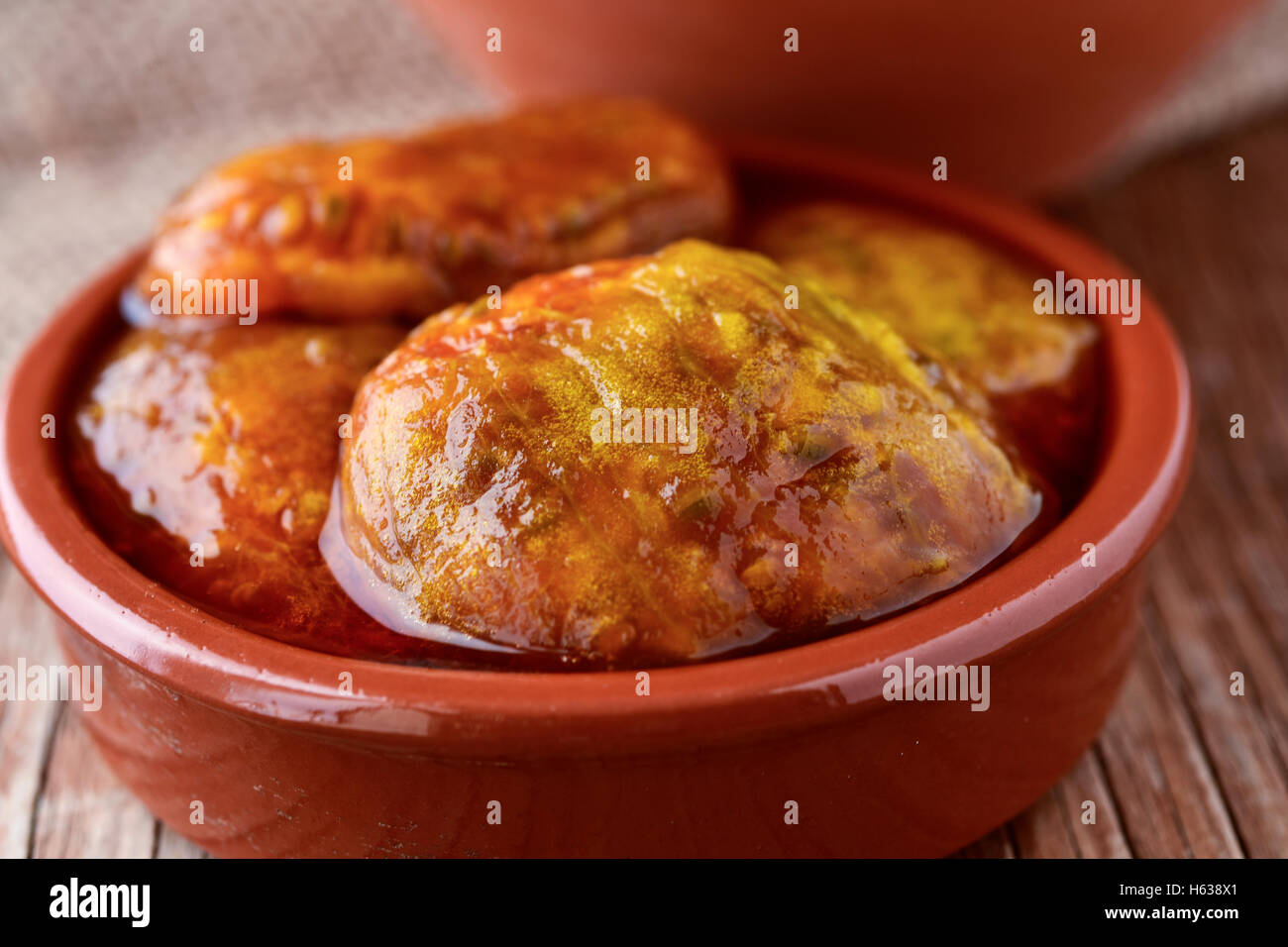 closeup of an earthenware bowl with peeled prickly pear fruits in their own juice, on a rustic wooden table Stock Photo