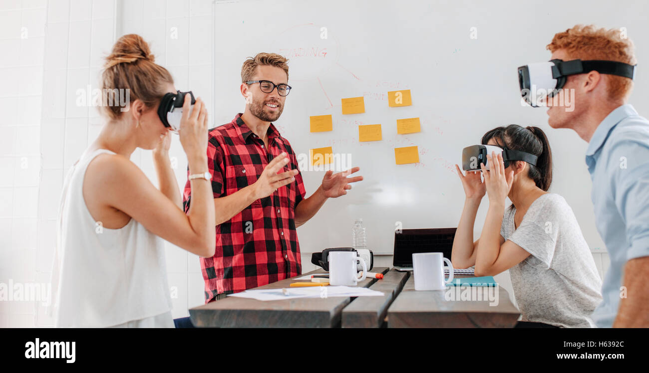 Business people using virtual reality goggles during meeting. Team of