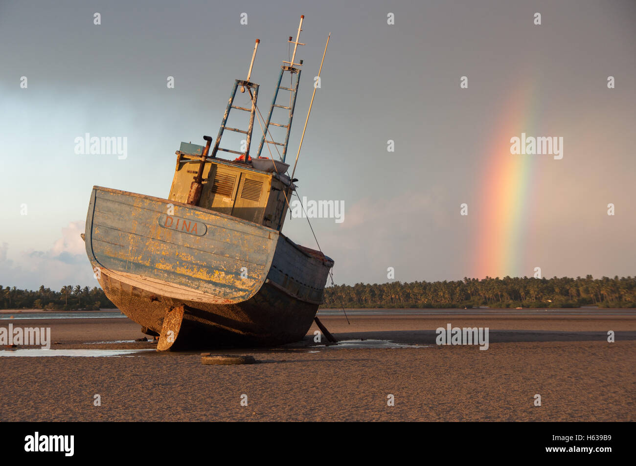 A photo of a disused vessel at low tide, captured in the foreground of a late afternoon thunderstorm, Inhambane Mozambique. Stock Photo