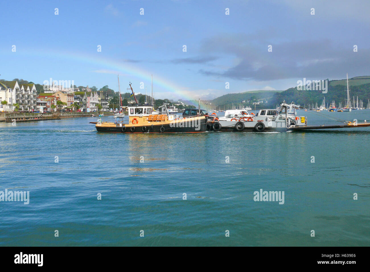 The Dartmouth Lower Ferry for cars and foot passengers plies between the town and Kingswear seen in mid river with rainbow. Stock Photo