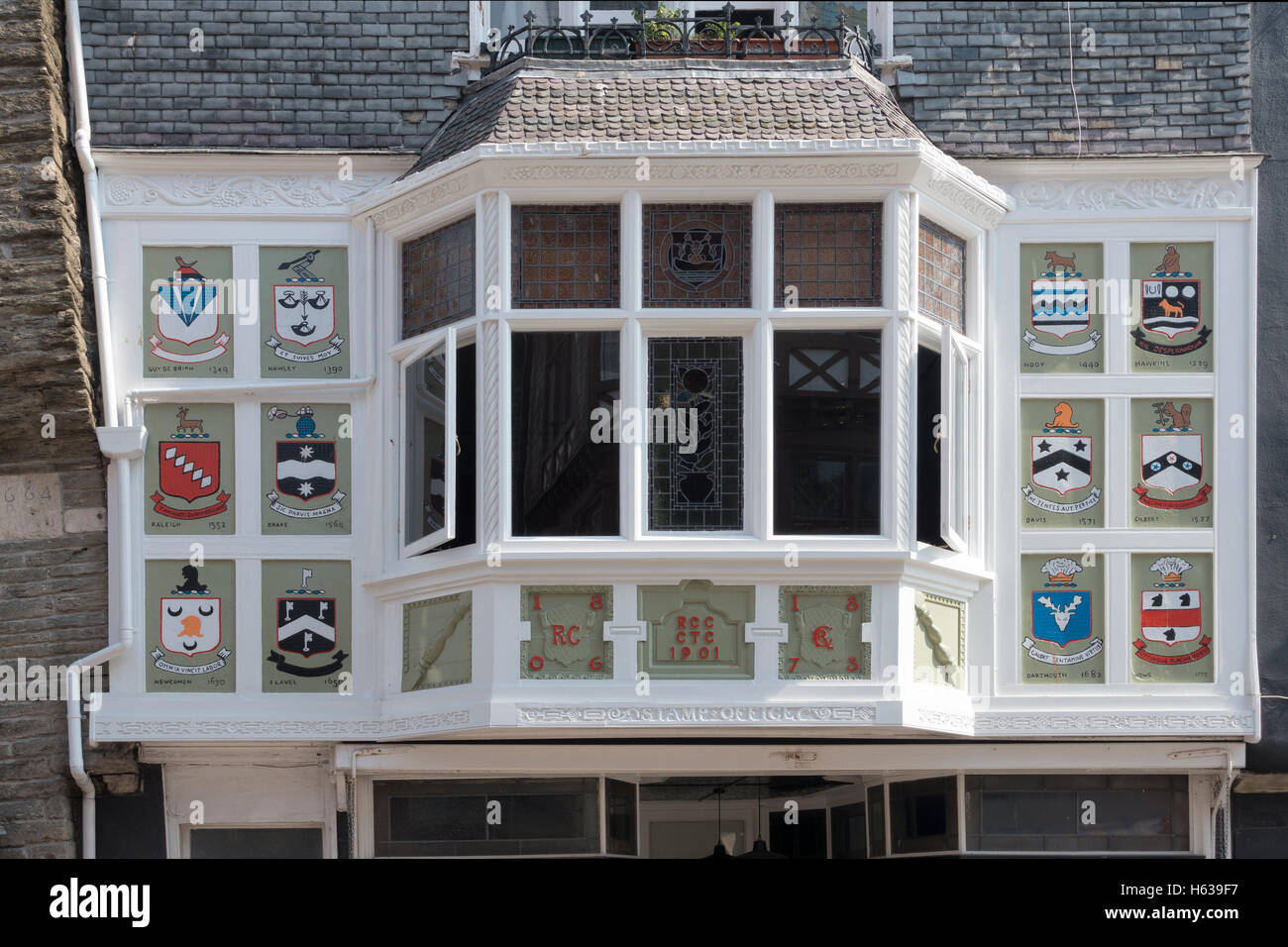 Colourful coats of arms surround this old bay window in Dartmouth, Devon UK Stock Photo