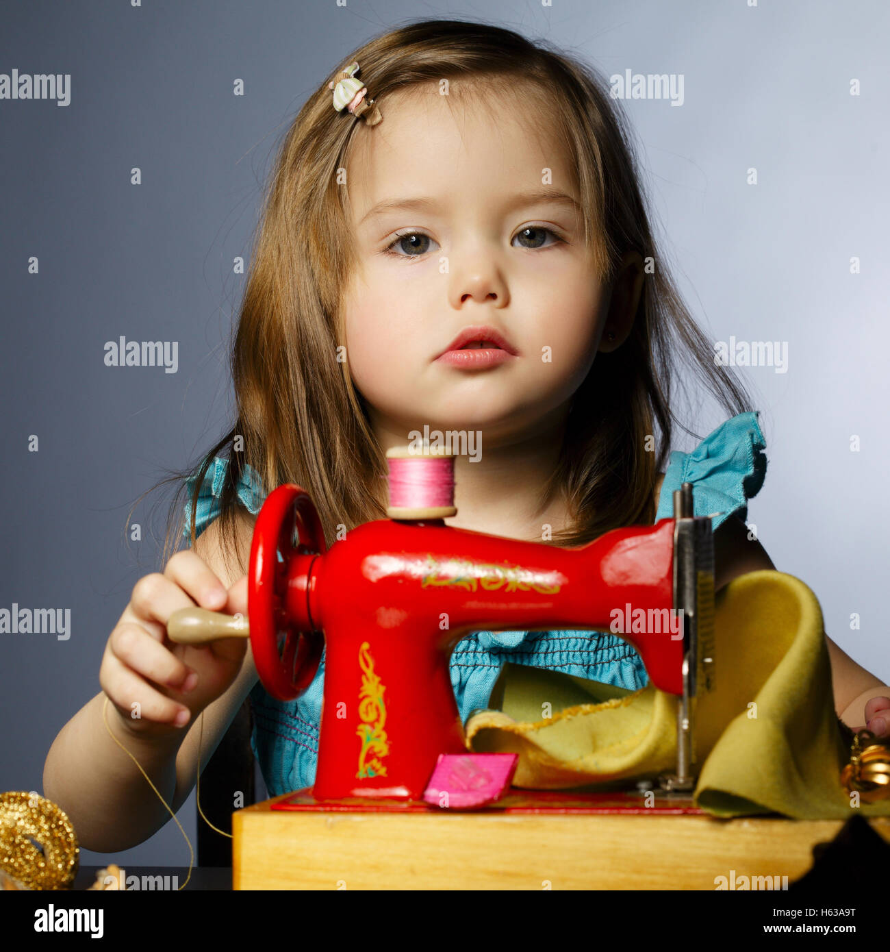 little girl is playing with sewing machine Stock Photo Alamy