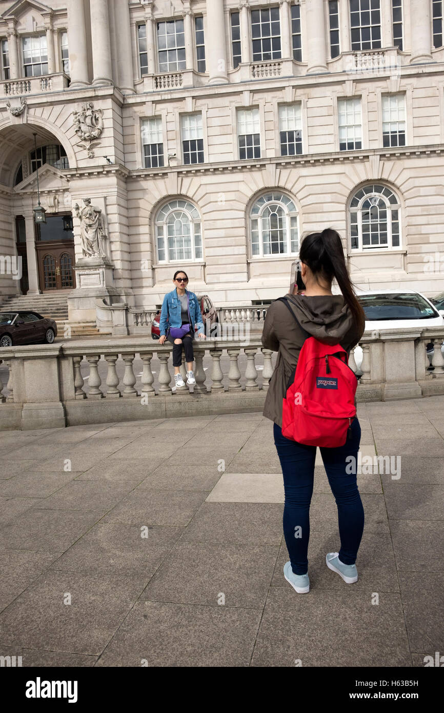 Tourists taking photographs outside building Stock Photo