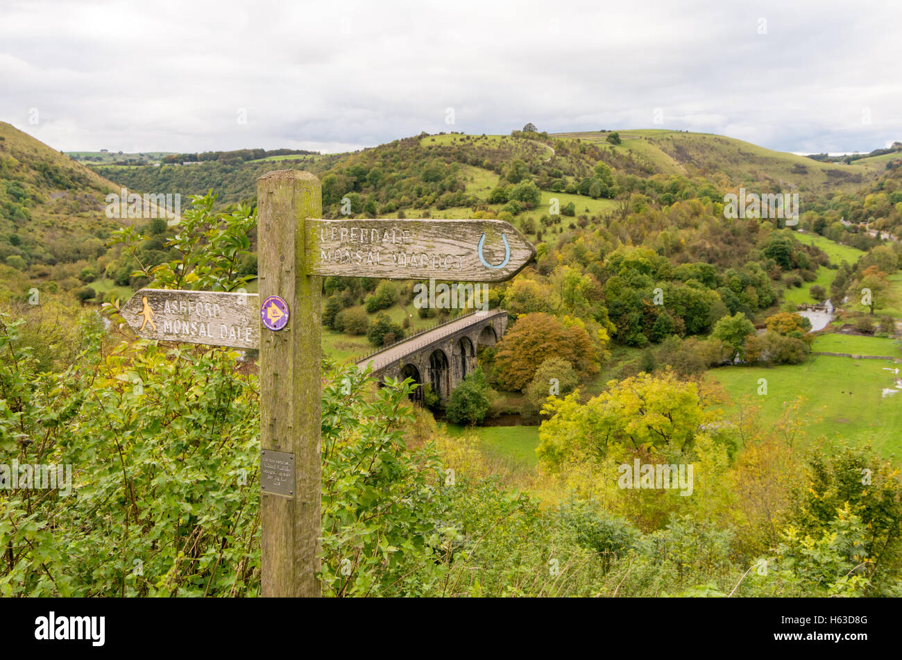 Looking down on the viaduct at Monsal Head in the Derbyshire Peak District, UK, past the footpath direction signpost. Stock Photo