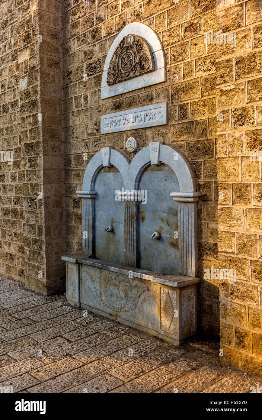 Beautiful old fountain in Jaffa with hebrew inscription from the Bible "For I will pourwater on
