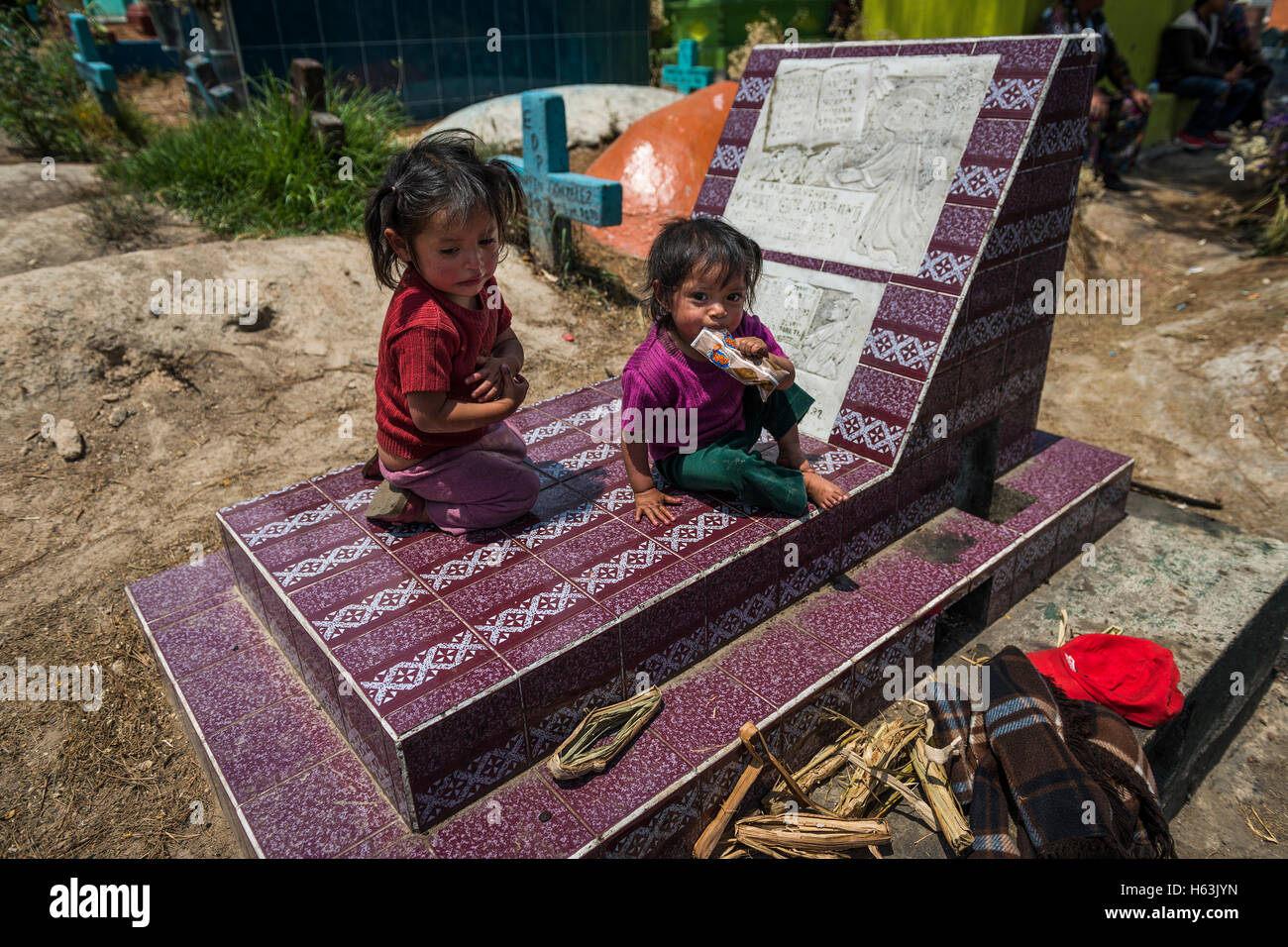 Chichicastenango, Guatemala - April 24, 2014: Children sitting in a grave in the cemetery of the town of Chichicastenango Stock Photo