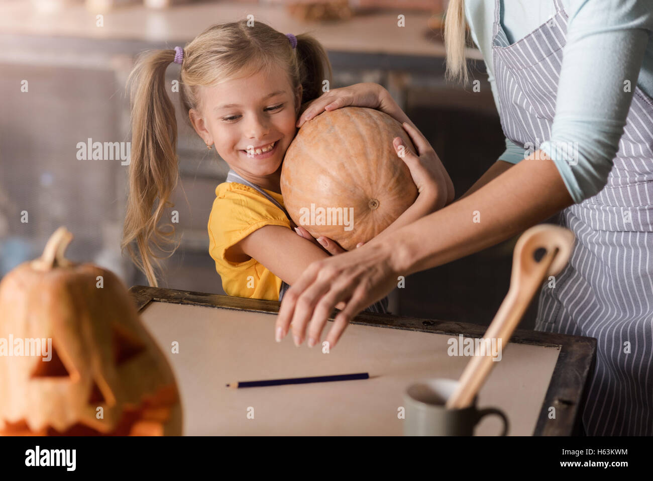 Cheerful little girl holding the pumpkin Stock Photo - Alamy