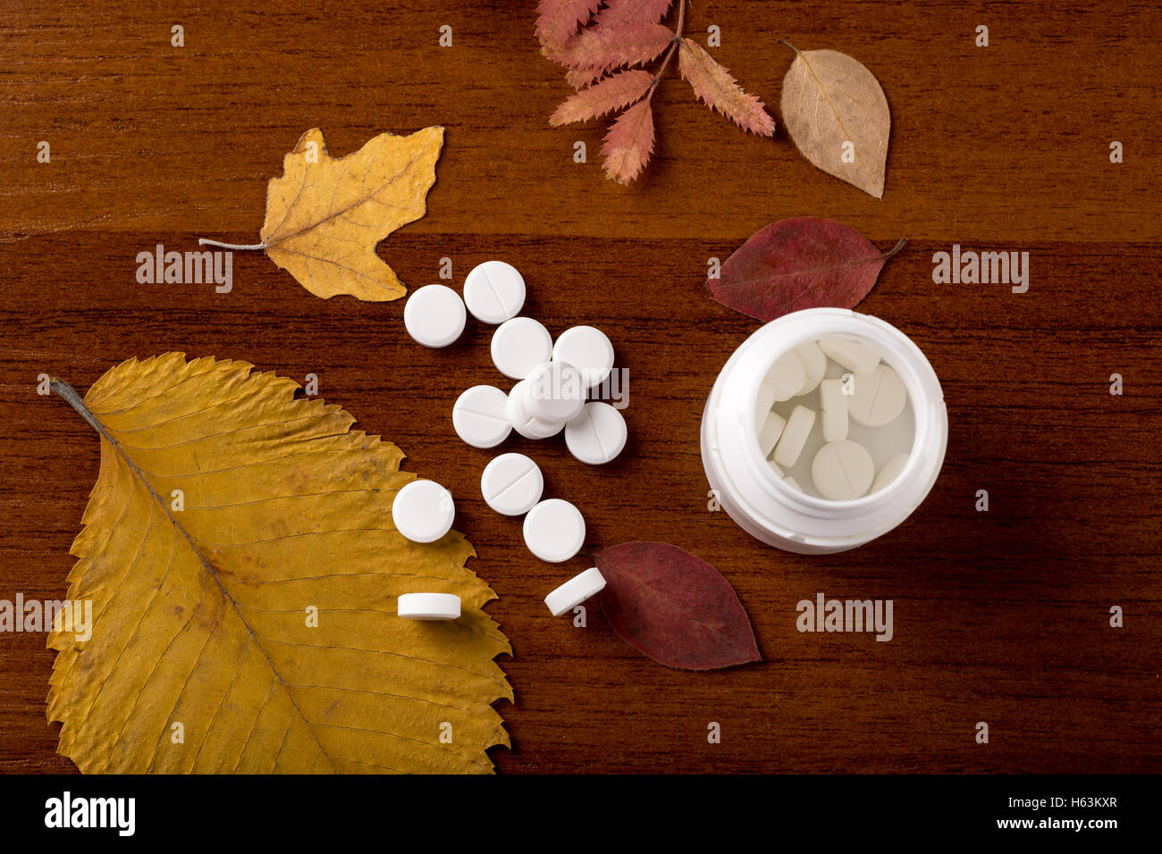 Heap of round white pills and pill bottle Stock Photo