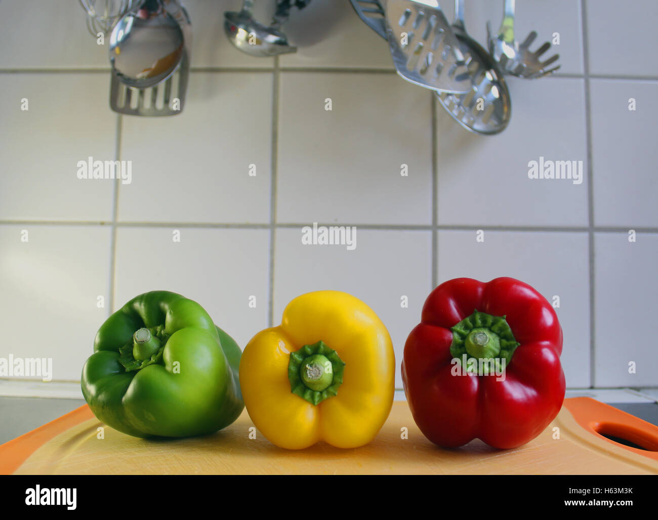 Green, yellow and red sweet pepper viewed from the front Stock Photo