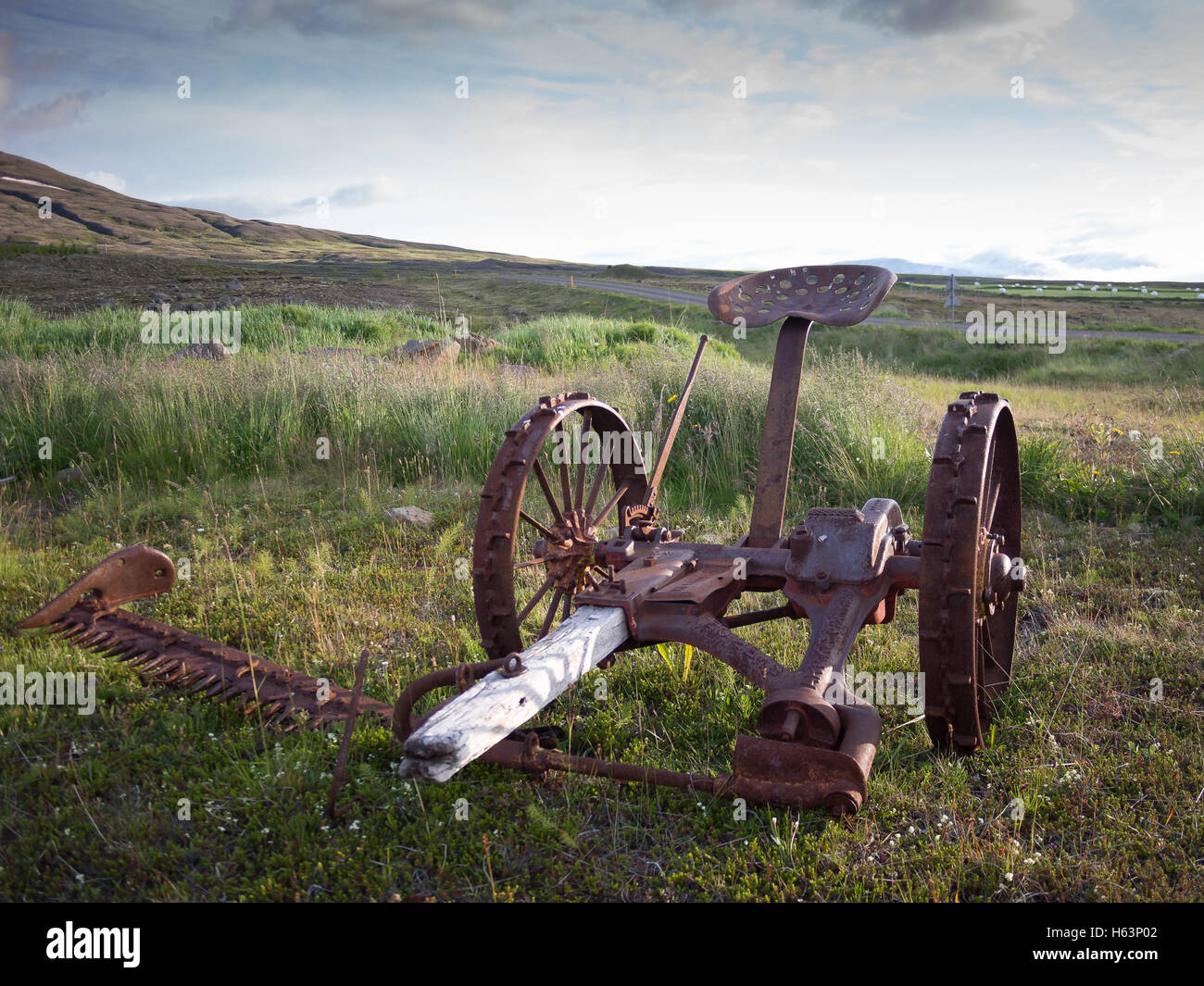 Solitary horse pulled grass cutter in a remote farm in Iceland Stock