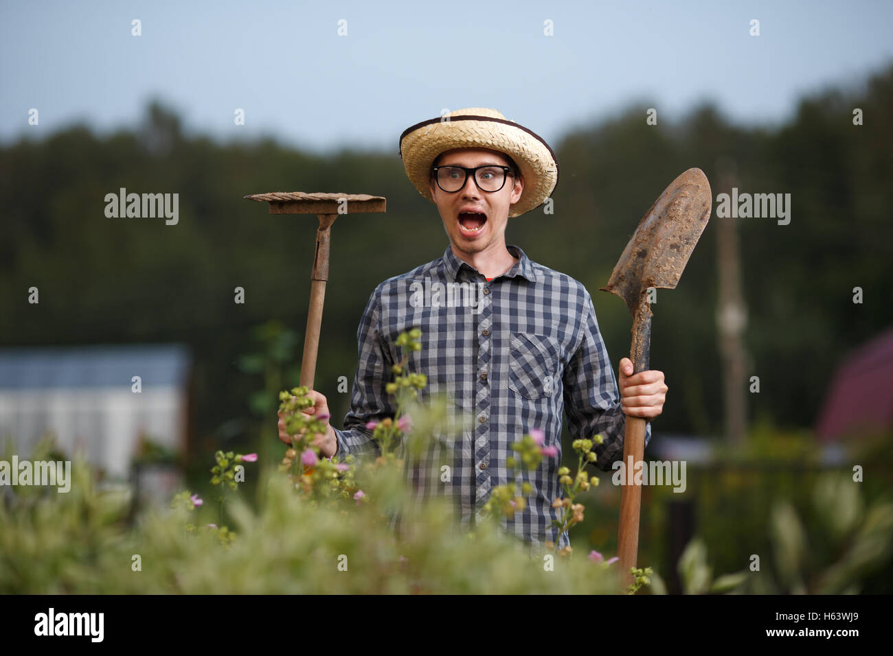 Funny expressive portrait of farmer man with shovel and rake with open ...