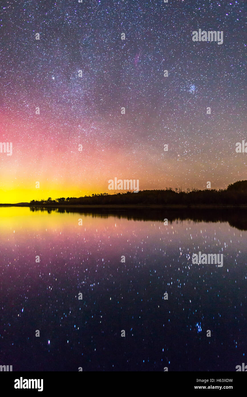 The rising autumn stars and constellations over and reflected in the lake at Police Outpost Provincial Park, in southern Alberta Stock Photo