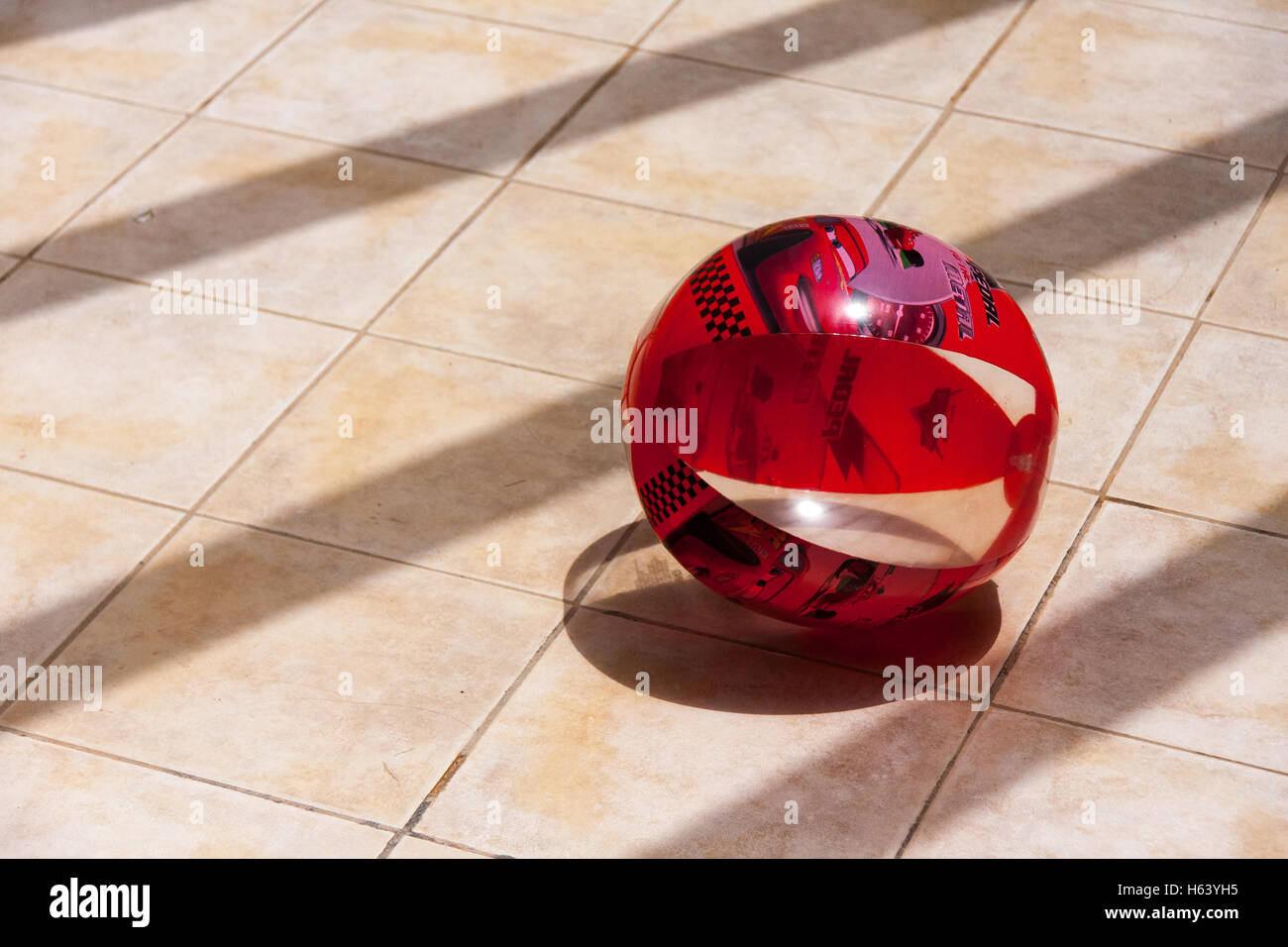 beach ball in sun on tiled floor Stock Photo