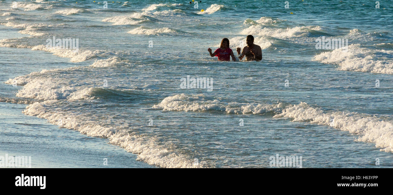 couple in sea, waves breaking Stock Photo