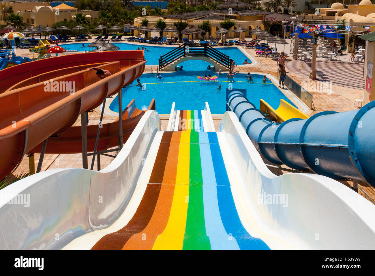 rainbow coloured water slide in water park Stock Photo